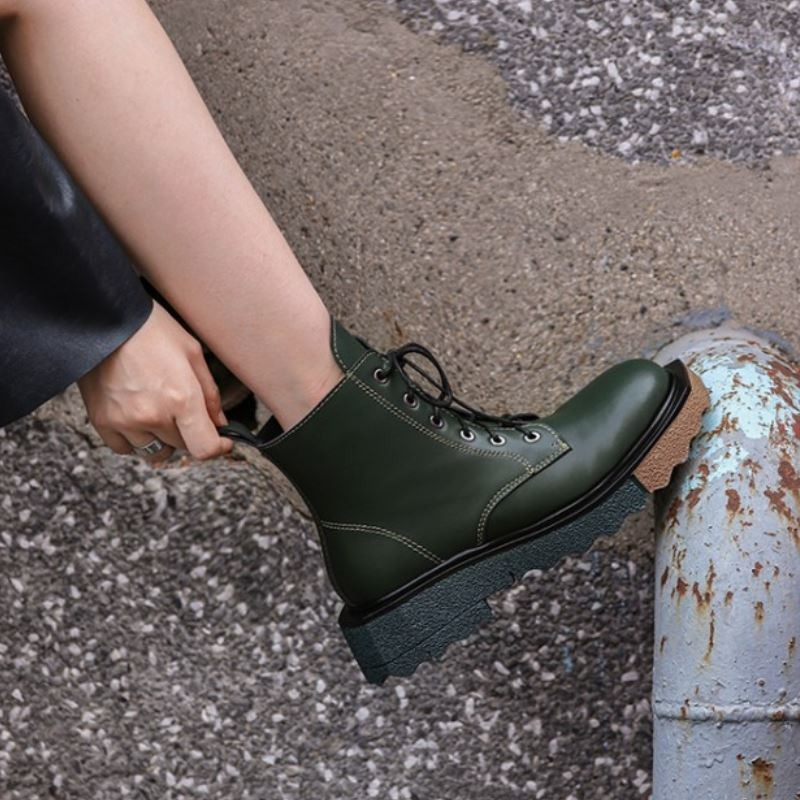 Stylish women's ankle boots in green leather with lace-up detail, perfect for trendy casual outfits.