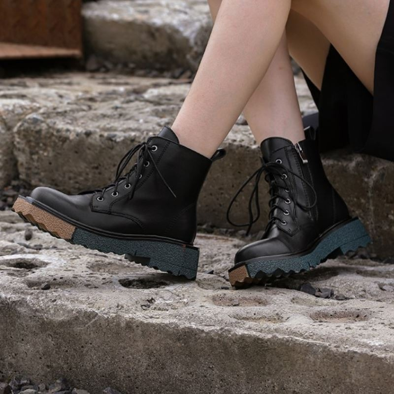 Stylish women's ankle boots in black leather with lace-up design and chunky sole, perfect for trendy outfits.