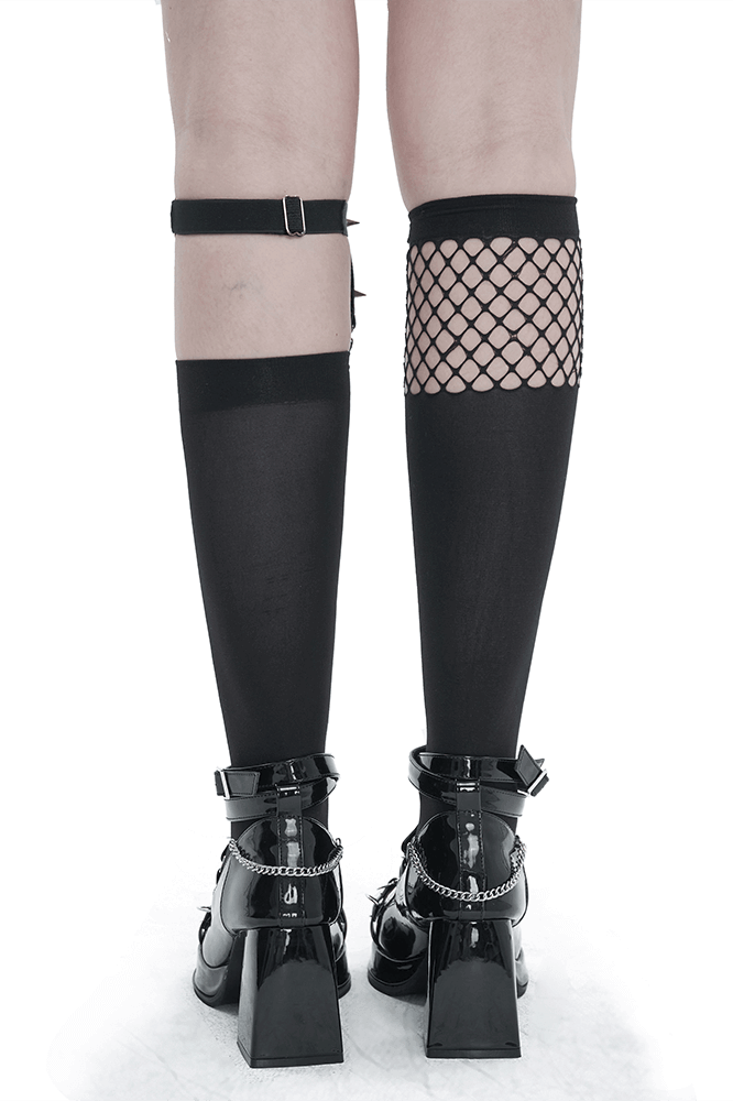 Back view of women's knee-length asymmetrical mesh splice socks with garter and metal heart, paired with chunky black heels.