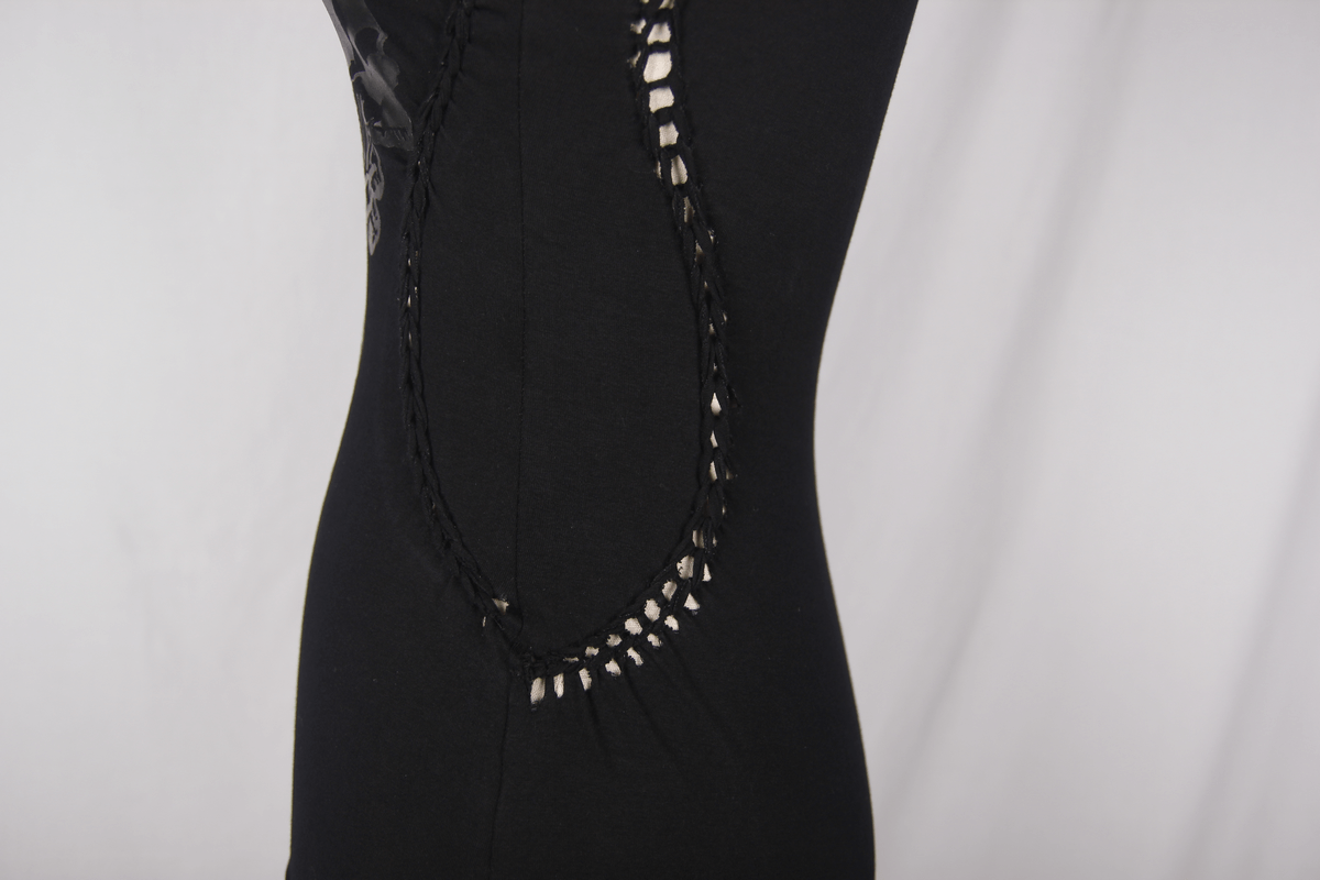 Close-up of women's black asymmetrical top featuring intricate mesh detailing on the side for a gothic punk look.