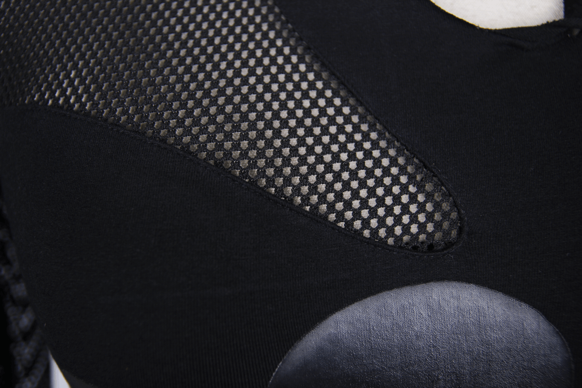 Close-up of a black asymmetric top featuring mesh details and unique texture elements, perfect for gothic punk style.