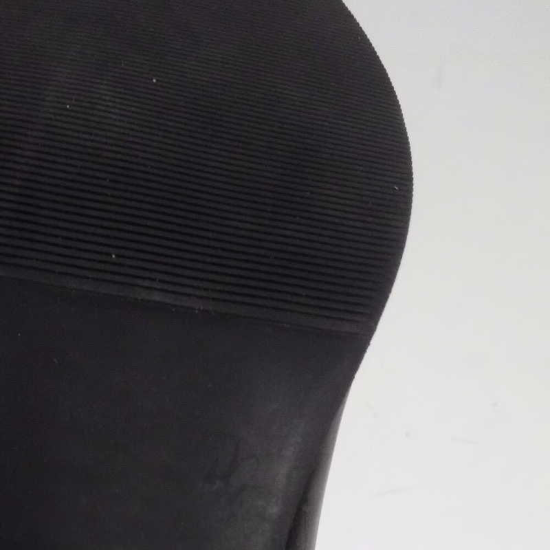 Close-up of the rubber sole of women's low heel ankle boots, showcasing texture and grip features.