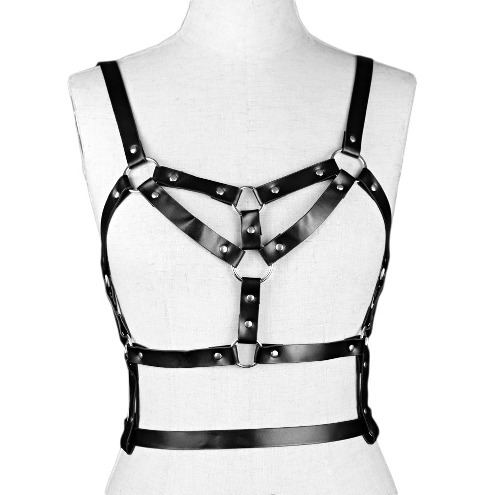 Women's adjustable faux leather harness belt seen from the back, featuring rivets and rings for a striking look.