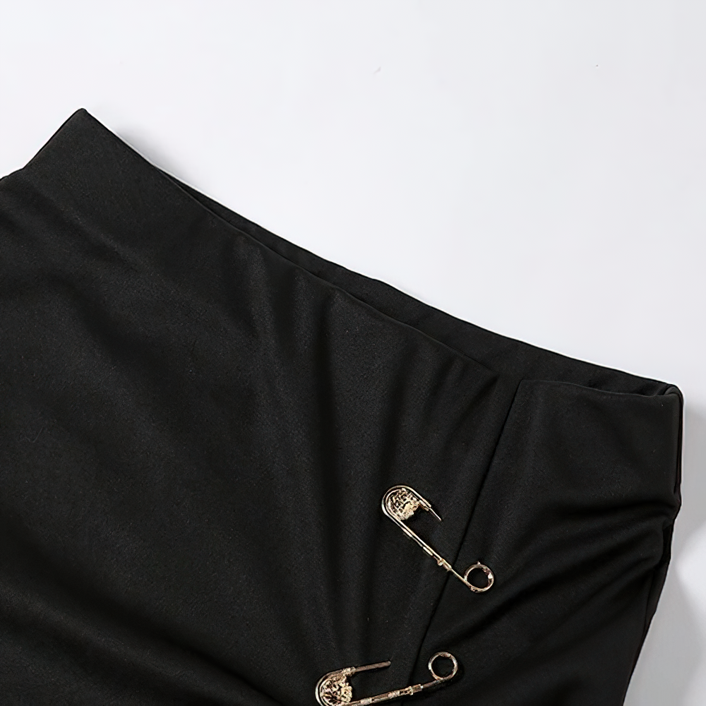 Close-up of a women's black gothic punk midi skirt featuring decorative safety pins and a high waist design.