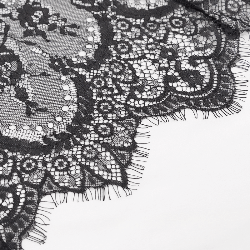 Close-up of intricate black lace fabric showcasing elegant floral patterns and delicate fringes.