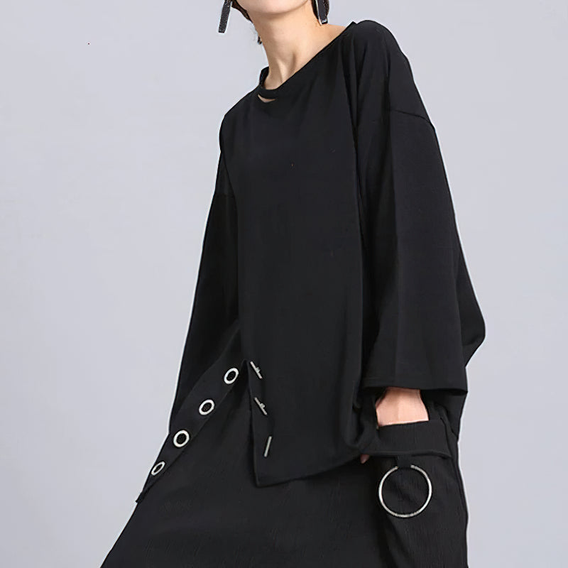 Fashionable women's black long sleeve top with asymmetrical design and unique metal accents, perfect for casual outfits.