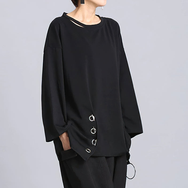 Women's black long sleeve top with asymmetric design and metal accents, perfect for casual outfits and warmer seasons.
