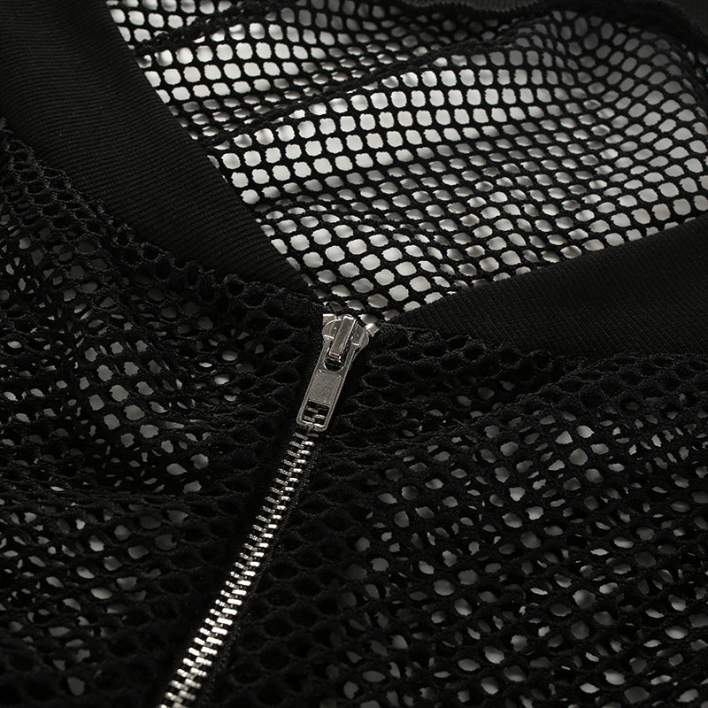Close-up of a black mesh fabric with a zip closure, showcasing the edgy detail of a stylish crop top.