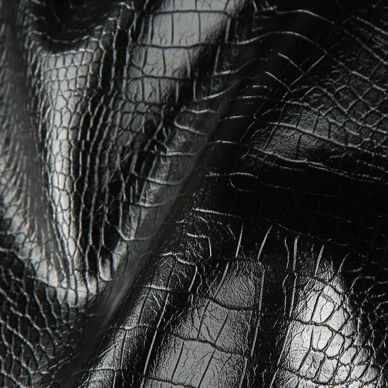 Close-up of high-quality black PU leather showing unique texture and shine for a stylish mini skirt.