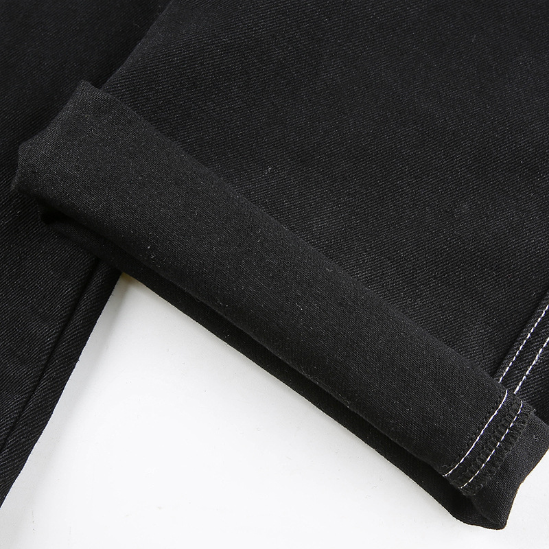 Close-up of rolled hem on women's black cotton straight high-waist pants, showcasing alternative streetwear style.