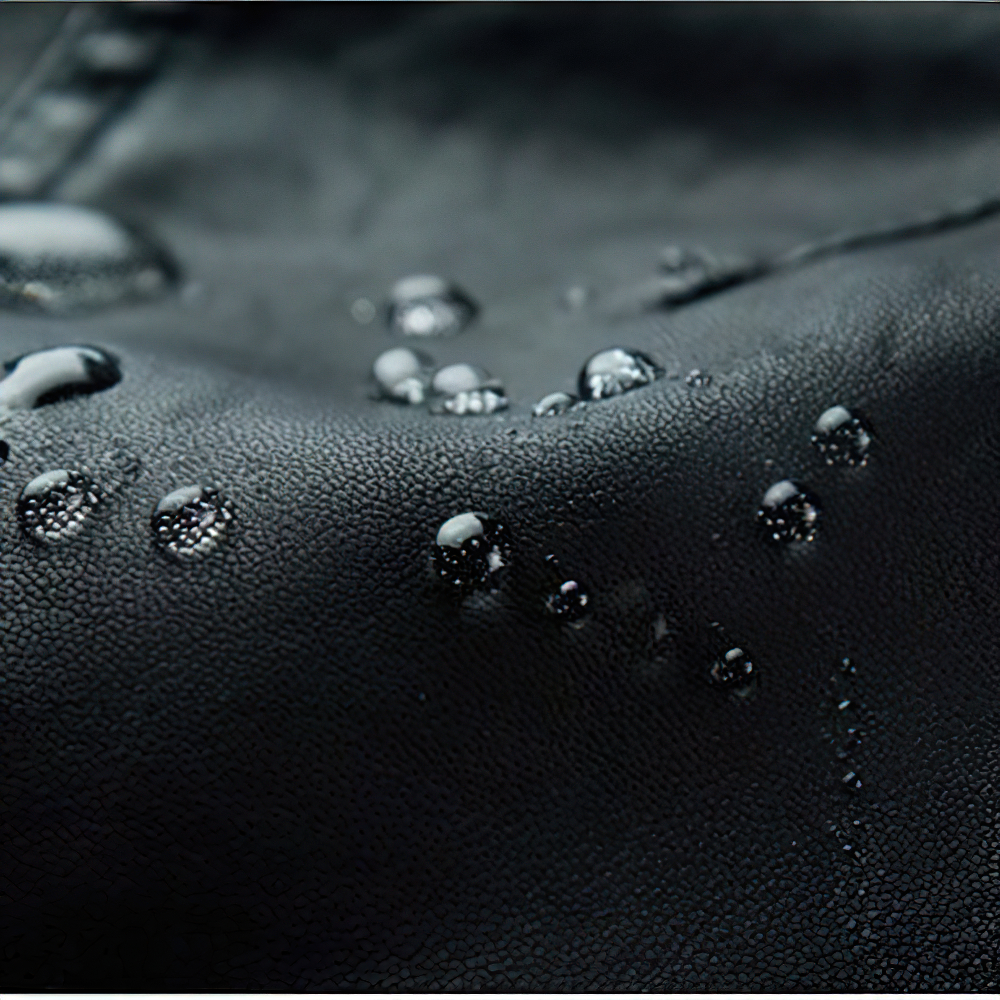 Close-up of water droplets on black PU leather, showcasing its stylish and durable quality.