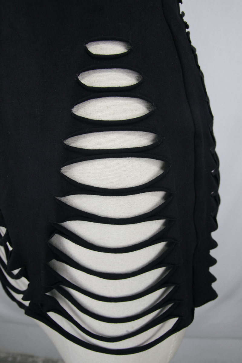 Close-up of black ripped tank top showcasing stylish torn inserts and edgy cut details.