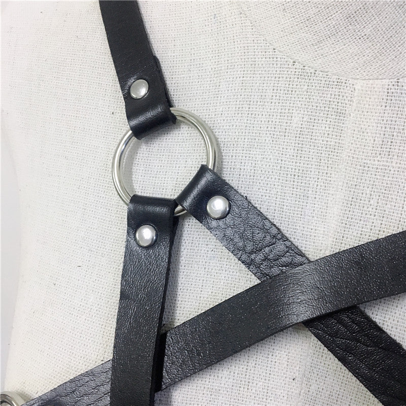 Close-up of a black women's body harness strap featuring a ring, showcasing gothic style and bondage elements.