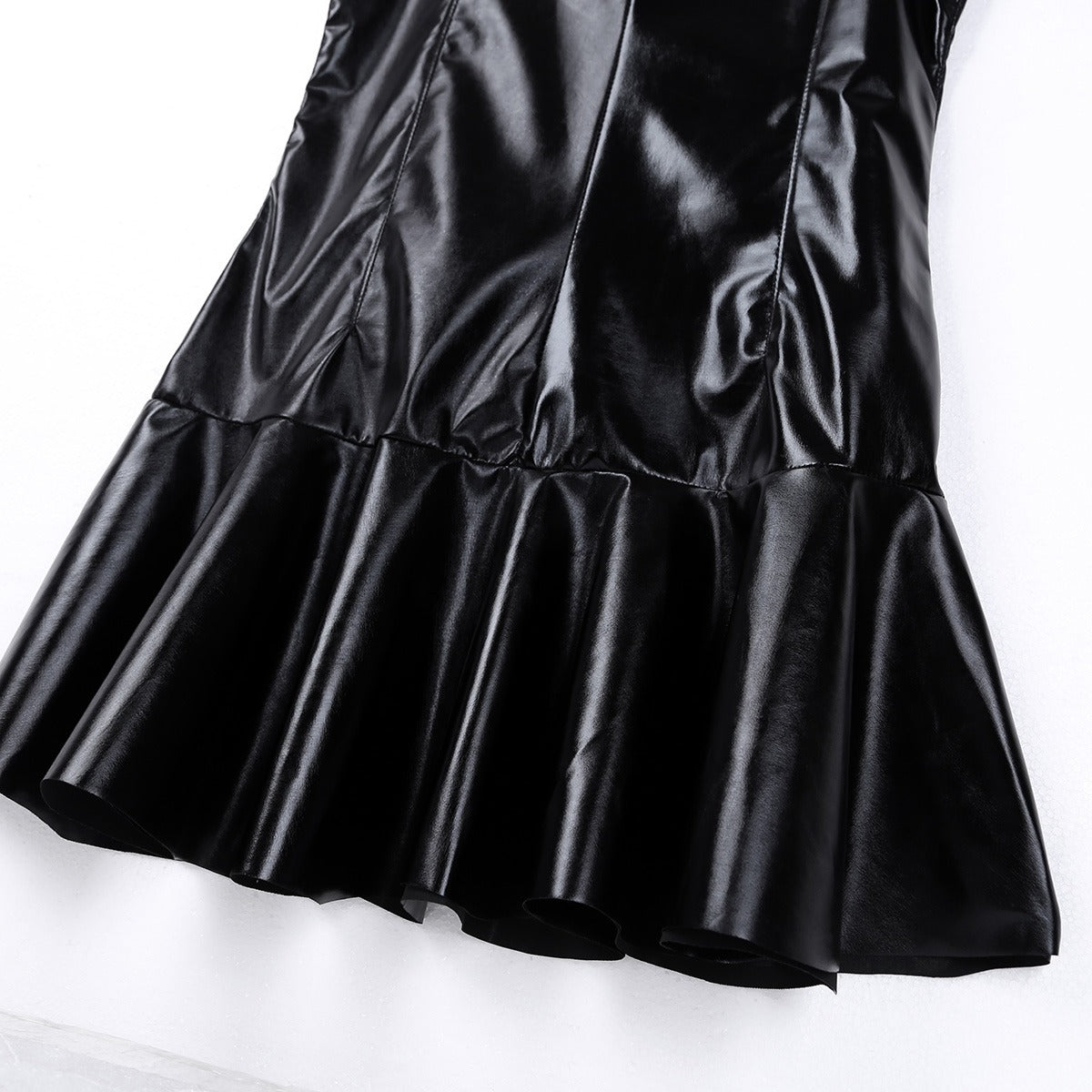 Close-up of a black PU leather mini cocktail dress with flared hem and glossy finish, perfect for stylish evenings.