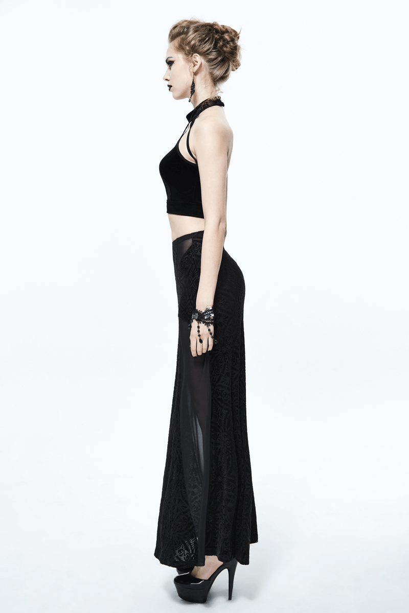 Side view of a stylish woman in a black crop top and elegant long skirt, embodying gothic fashion.