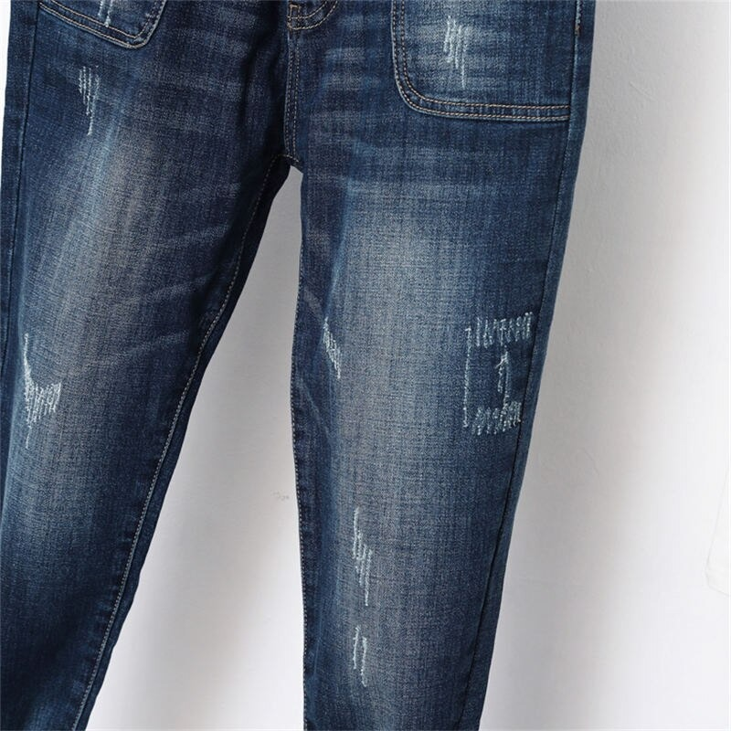 Close-up of women's loose jeans in blue with distressed details and pockets, perfect for stylish streetwear.