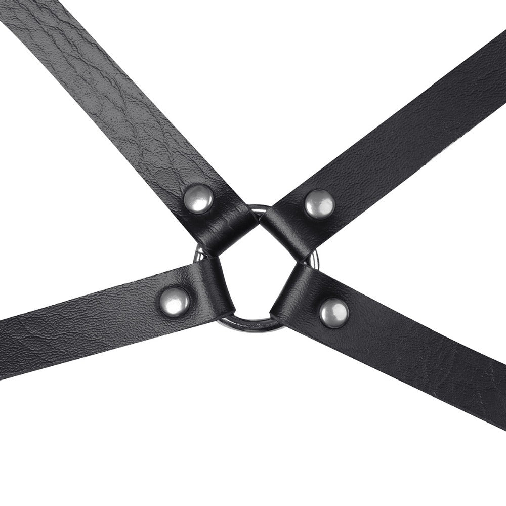 Close-up of a black faux leather adjustable body harness with metal ring and studs, ideal for gothic fashion.