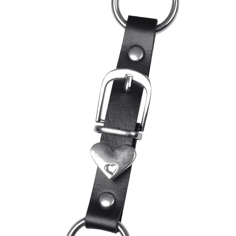 Close-up of black faux leather body harness strap featuring heart buckle and metal rings, ideal for gothic and cosplay styles.