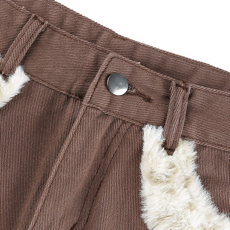 High waist detail of women's furry leopard jeans skirt showcasing stylish fur inserts and button closure.
