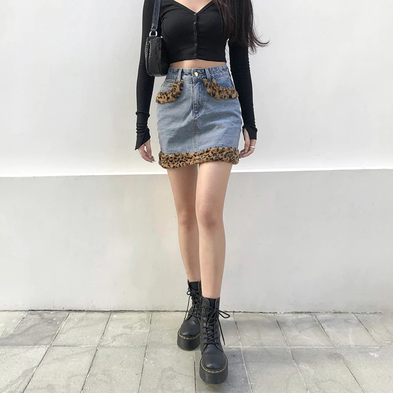 Stylish women's high waist jeans skirt with leopard fur details, paired with a black crop top and combat boots.