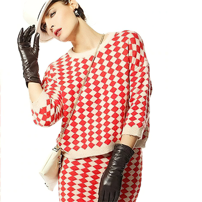 Stylish woman in red diamond-patterned outfit paired with elegant black leather gloves and white hat.