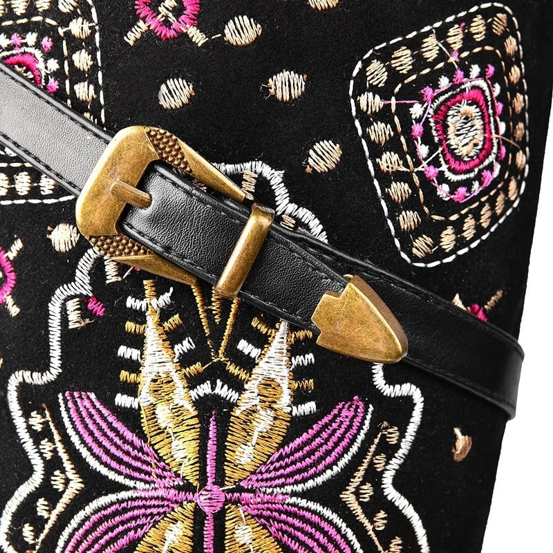 Close-up of a stylish embroidered detail on women's leather western boots with a decorative buckle.
