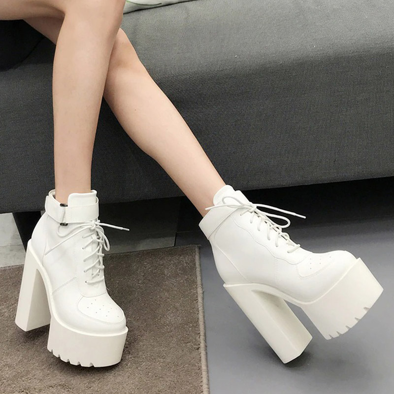 Stylish white lace-up high-heeled ankle boots on display, perfect for alternative fashion and punk outfits.