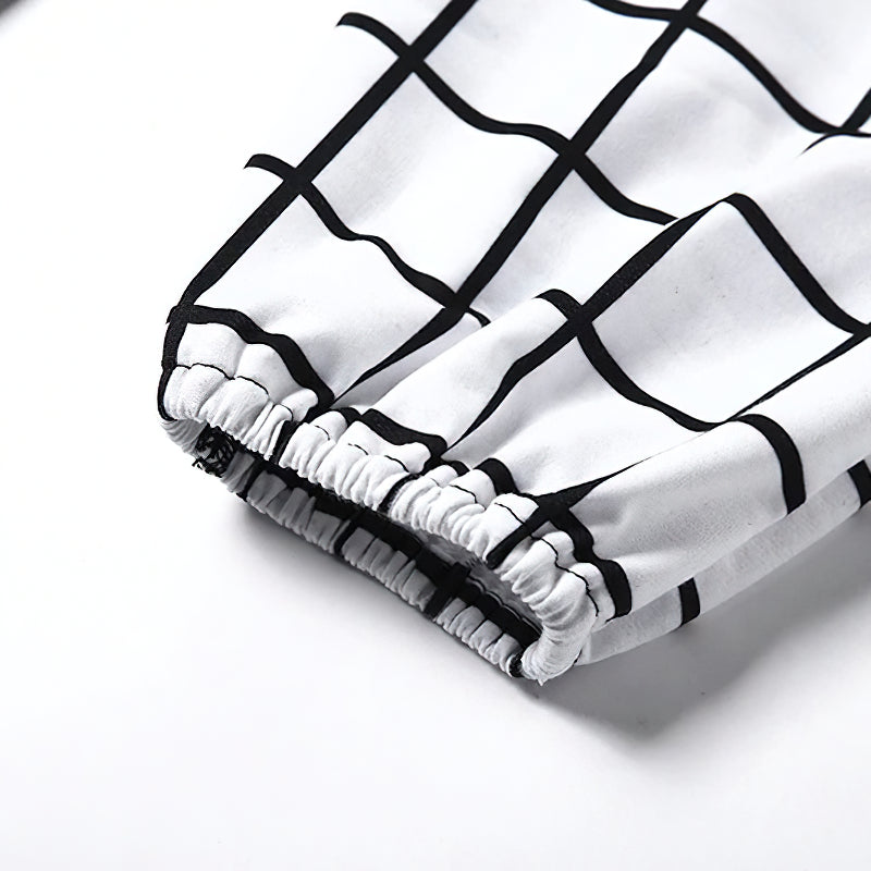 Close-up of elastic cuff detail on women's black-and-white checkerboard gothic cargo pants.