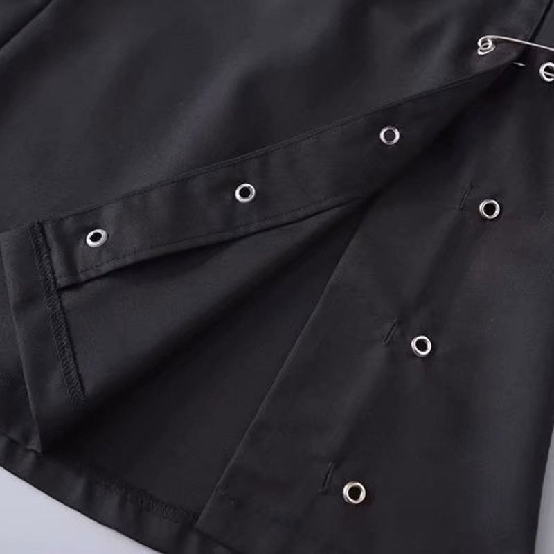 Close-up of a black low waist A-line skirt with silver clips and eyelets, showcasing stylish gothic design details.
