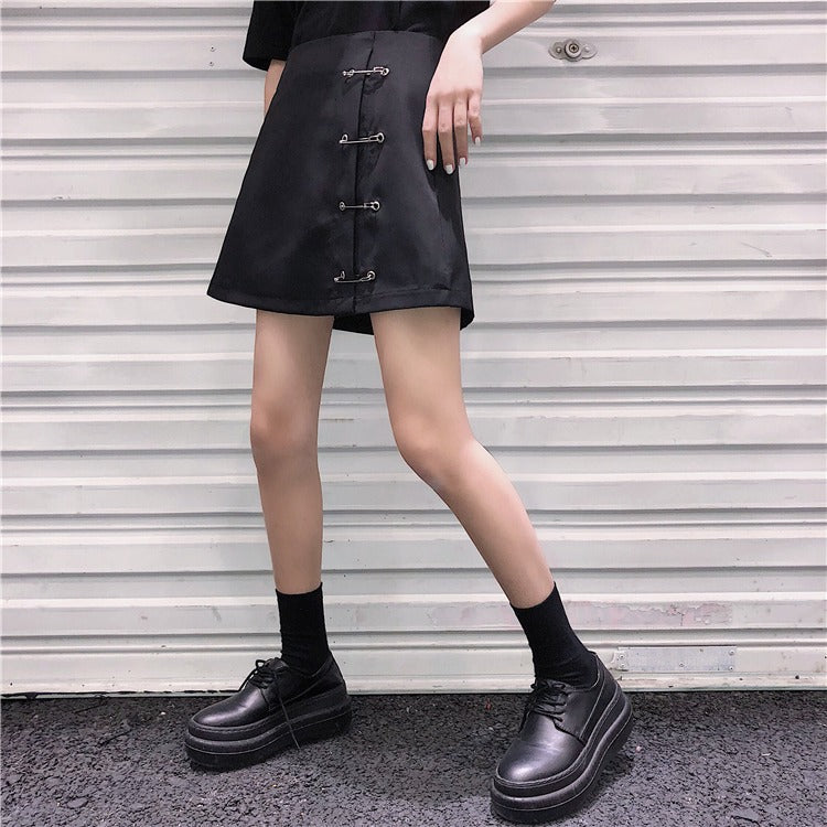 Low waist A-line black skirt with clips, perfect for a gothic look, paired with chunky shoes and socks.