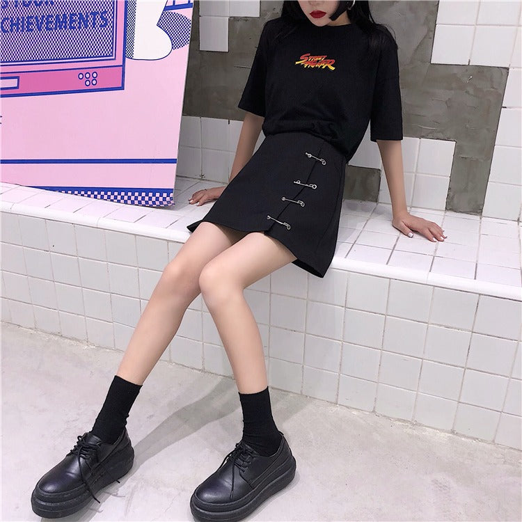 Stylish girl in black A-line short skirt with clips and black t-shirt, showcasing a trendy gothic look.