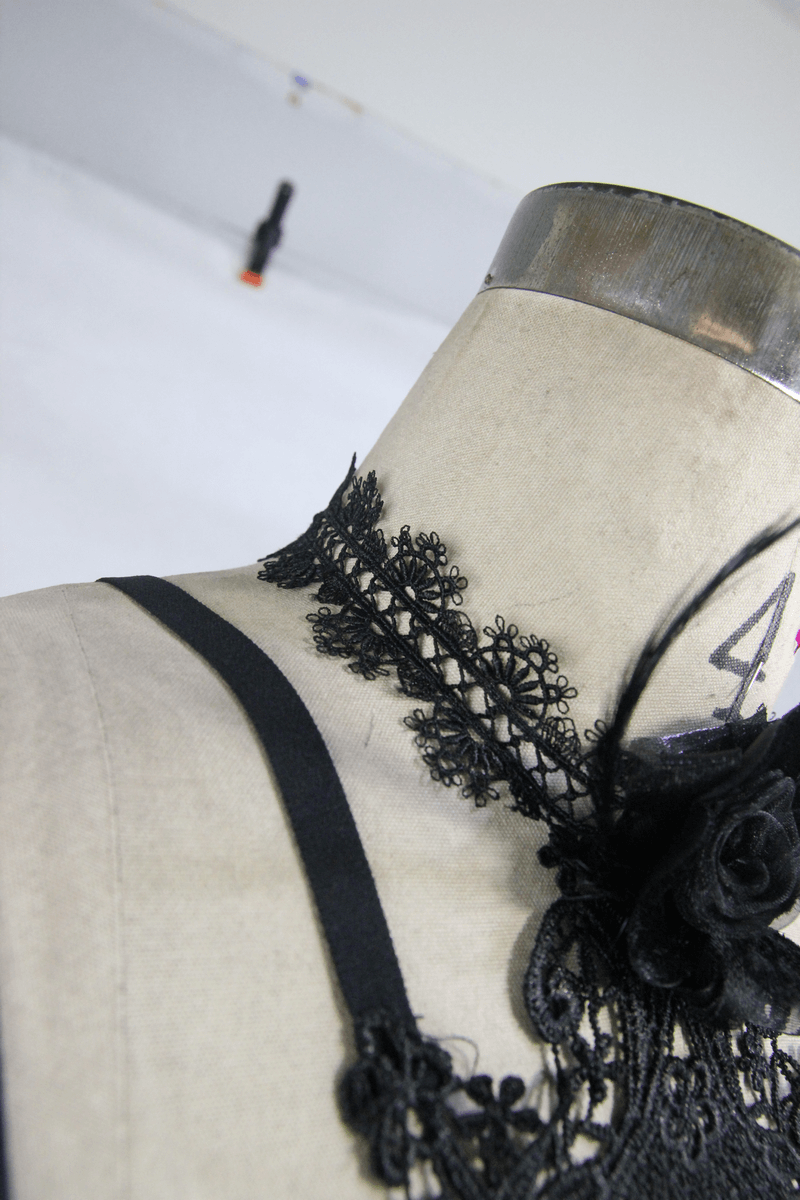 Close-up of a women's gothic lace harness with intricate 3D flowers on a mannequin, highlighting elegant design details.