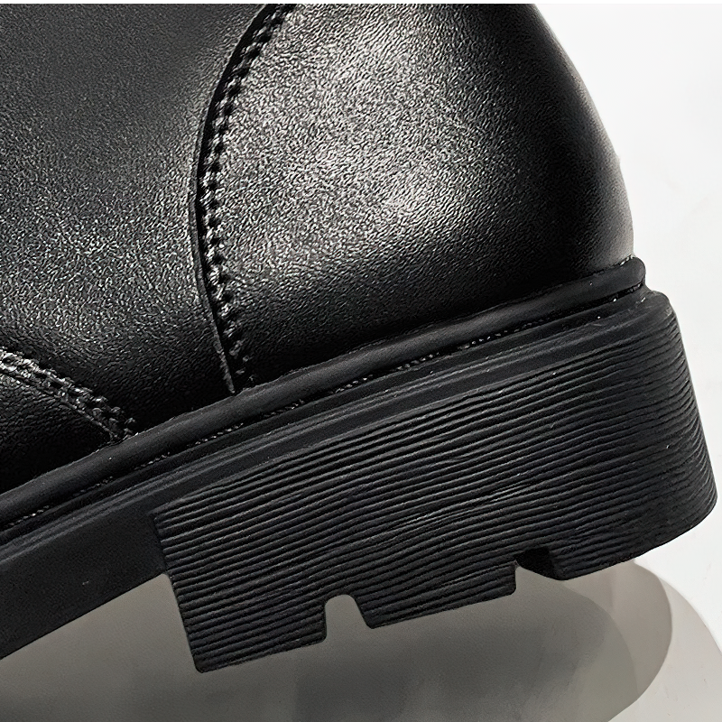Close-up of black women's lace-up ankle motorcycle boot showcasing sleek PU leather and durable rubber sole.