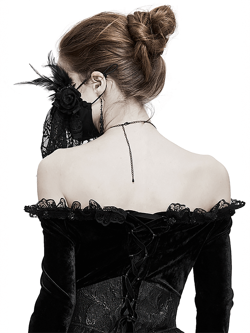 Elegant woman in gothic black dress wearing a lace veil face mask with flowers and feathers, showcasing vintage charm.