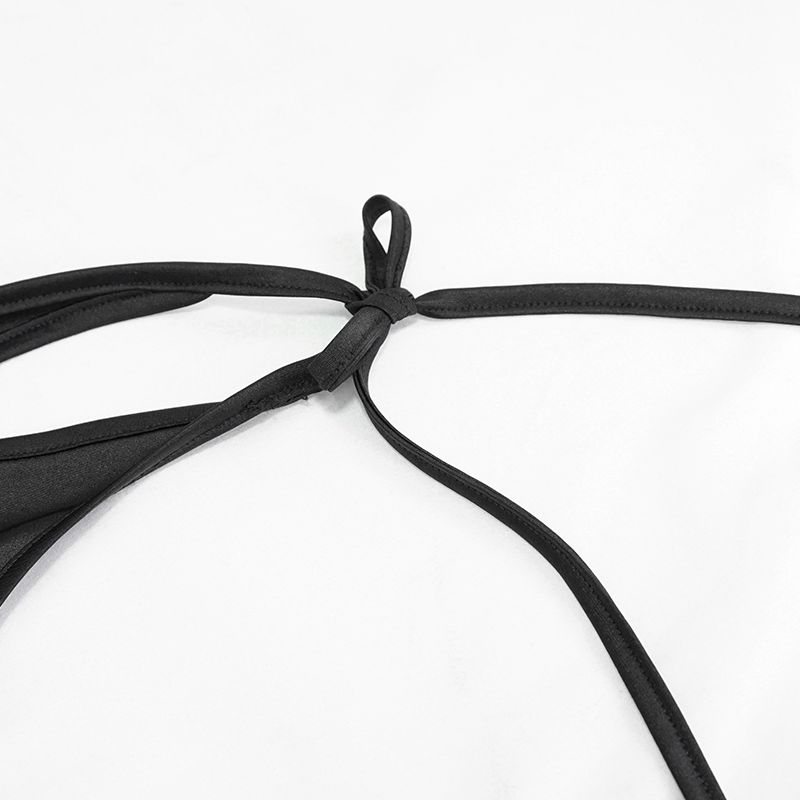 Close-up of black lace-up detail on women's gothic bikini, showcasing stylish ribbons and knots.