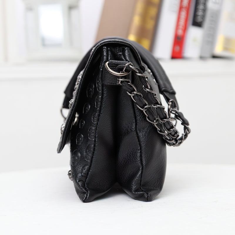 Stylish women's leather gothic shoulder bag with rivet skull design and chain strap side view.
