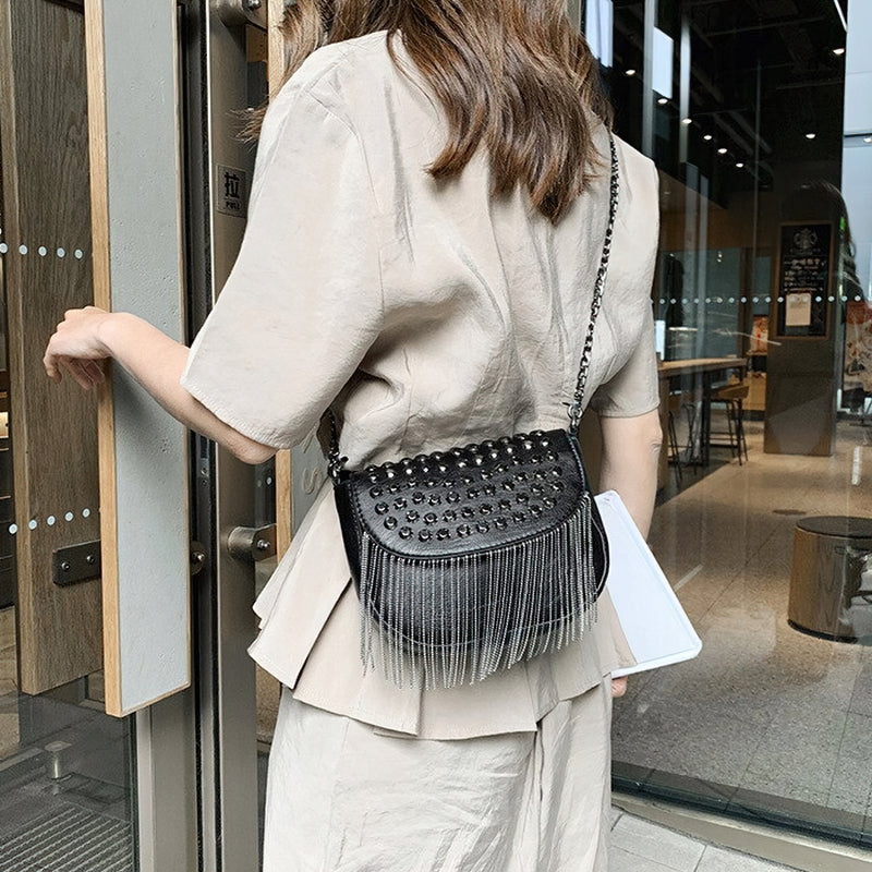 Elegant women's leather shoulder bag with rivets and fringe, perfect for casual outings and stylish outfits.