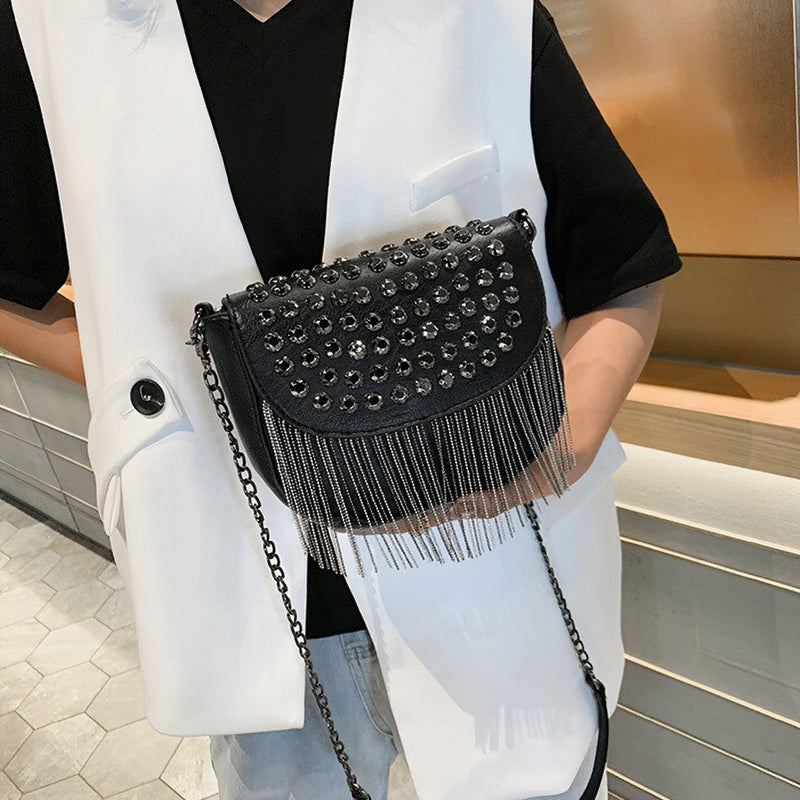 Elegant women's leather shoulder bag with rivets and fringe, perfect for casual outfits and stylish outings.