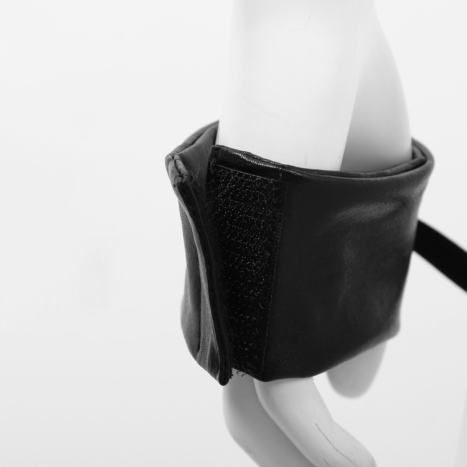 Close-up of a black elastic strap with velcro detail, showcasing unique lingerie design and style.