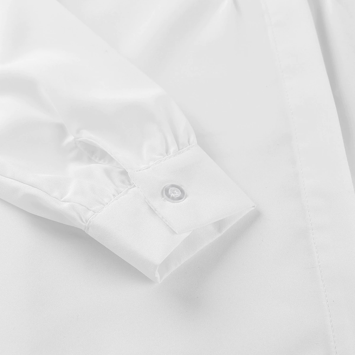Close-up of white women's long sleeve button-up shirt cuff with button detail.