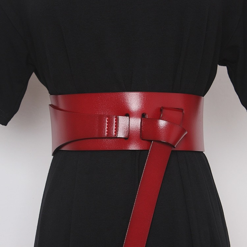 Women's long red PU leather designer belt accentuating the waist, perfect for adding style to any dress.