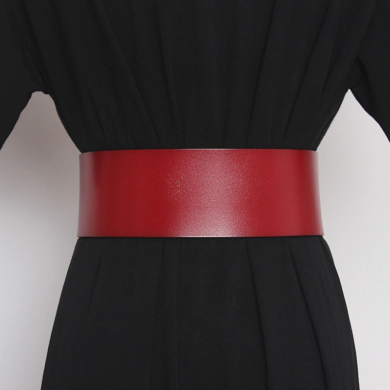 Stylish red PU leather belt on a black dress, perfect for accentuating the waist and elevating outfits.