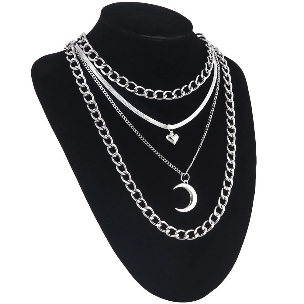 Layered silver chain necklace featuring a moon and heart pendant for a trendy gothic style.