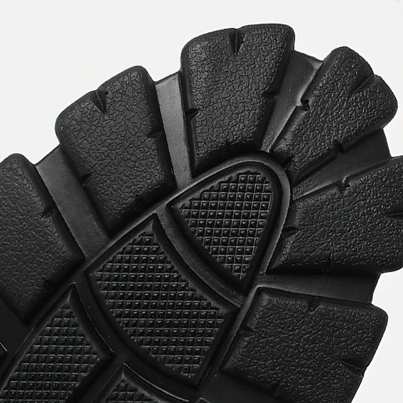 Close-up of a rugged black boot sole featuring textured grips for enhanced traction and style.