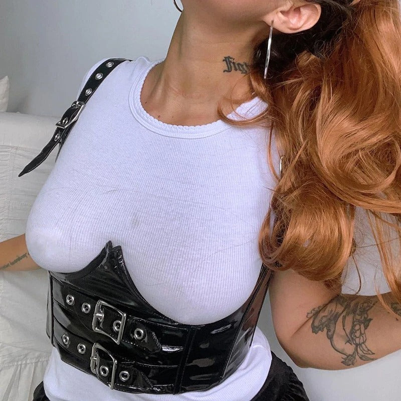 Women's Gothic PU Leather Tank Top with shiny buckles, styled over a white shirt for a bold, grunge look.