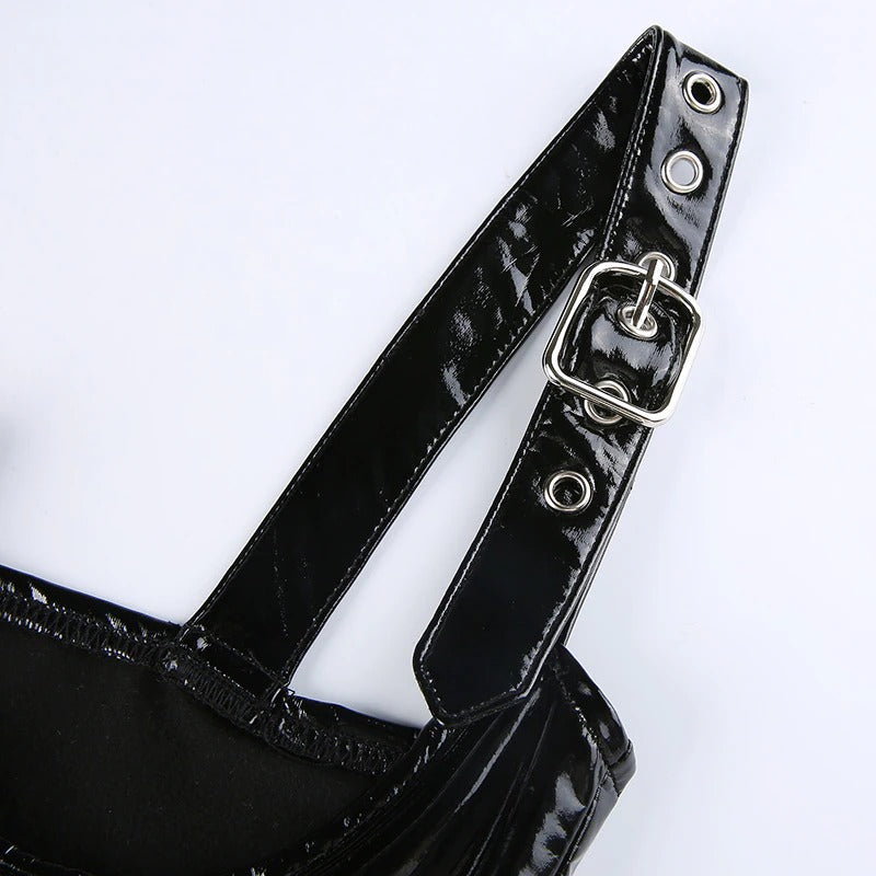 Close-up of shiny black PU leather tank top strap featuring silver buckles and bold grommet details.
