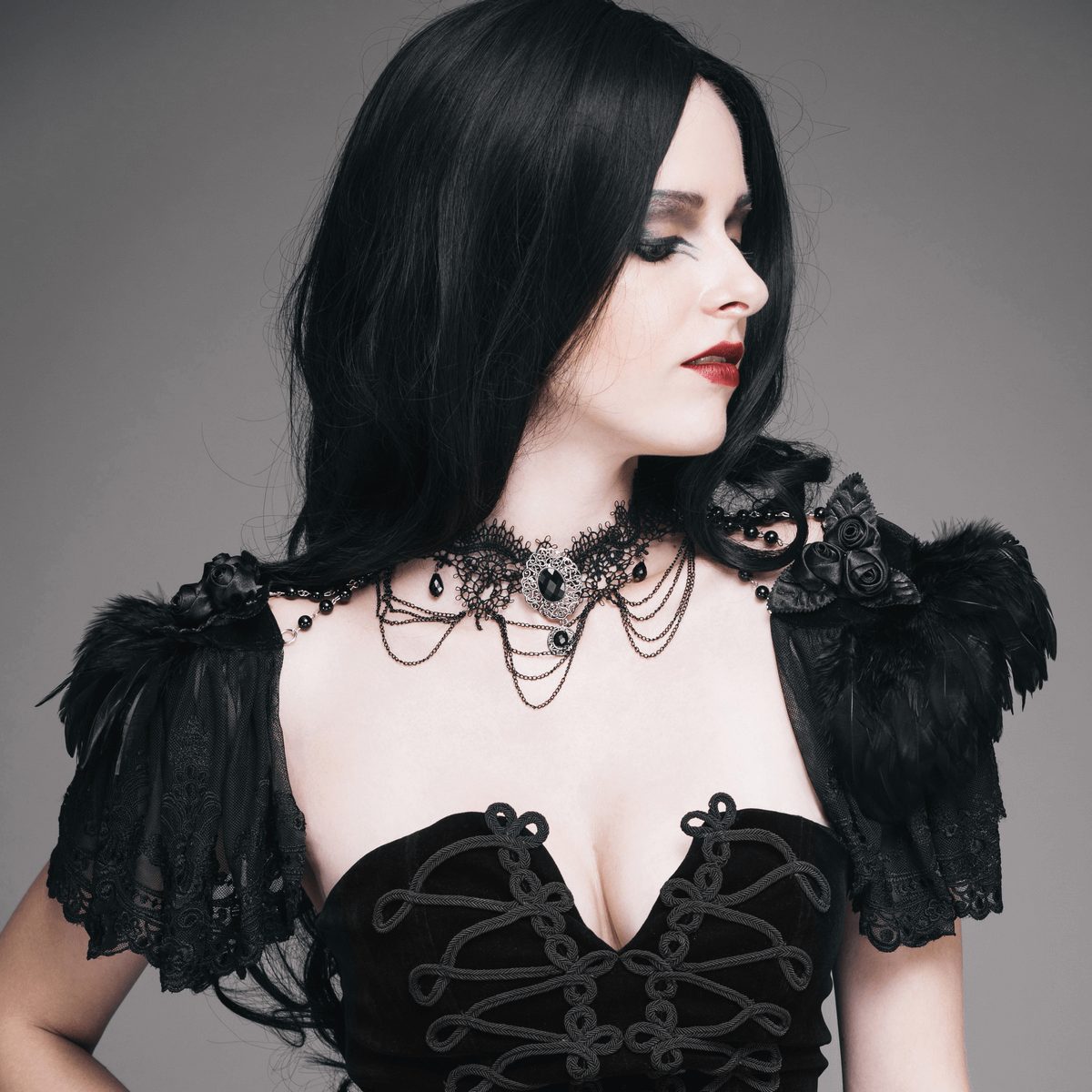 Elegant woman in punk style outfit with black shawl sleeves and intricate beaded necklace, showcasing vintage fashion vibes.