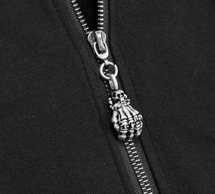 Close-up of a black coat zipper featuring a unique silver skeleton hand charm.