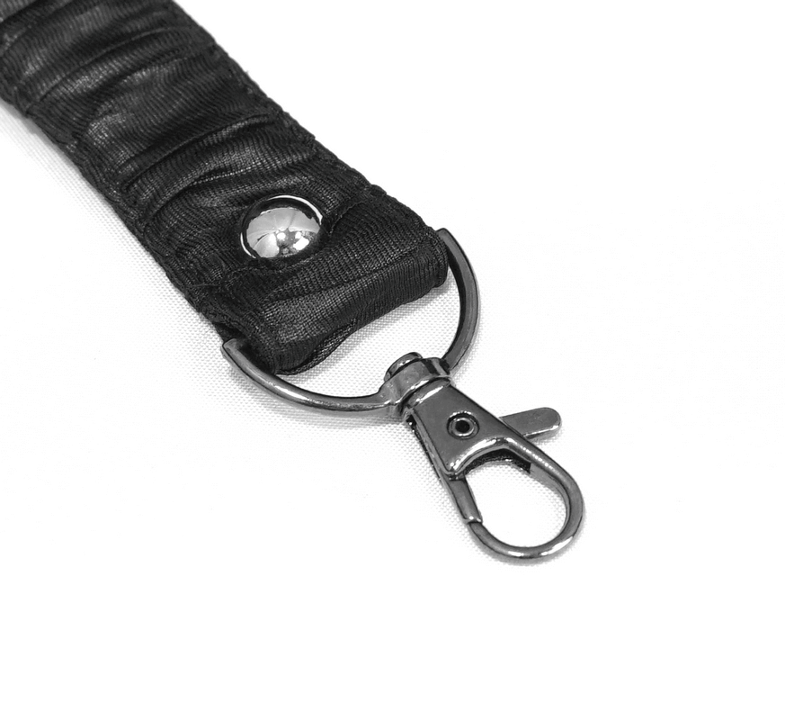 Close-up of a stylish black fabric strap with snap hook and silver accents for bags and accessories.