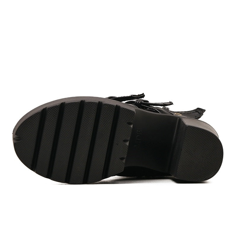 Bottom view of black gothic rivet platform boots showcasing thick square heel and textured sole.